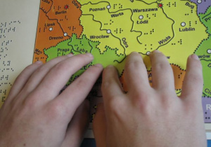 Dłonie czytające mapę brajlowską